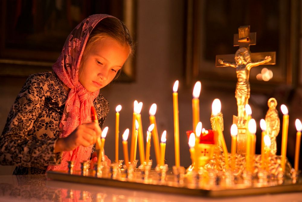 Девочка возле церковных свечей