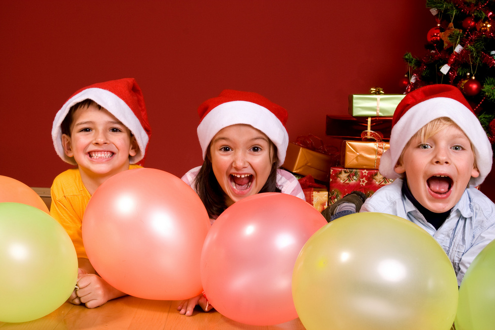 Дети в новогодних колпаках с воздушными шарами