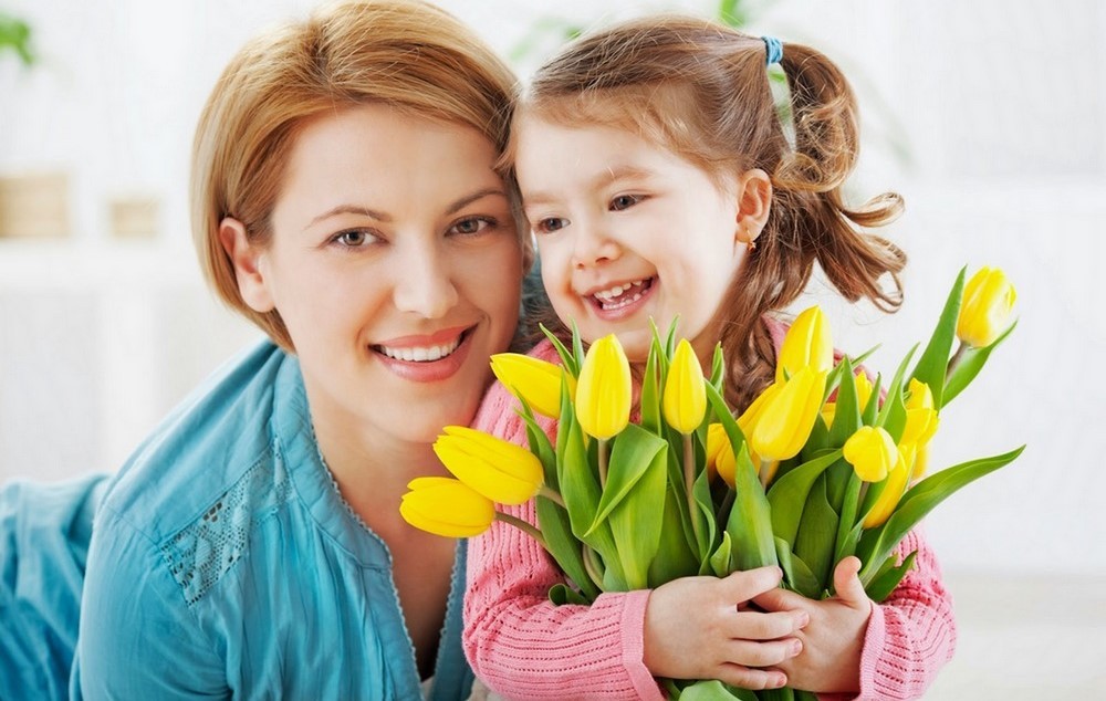 Девочка с тюльпанами в руках возле мамы