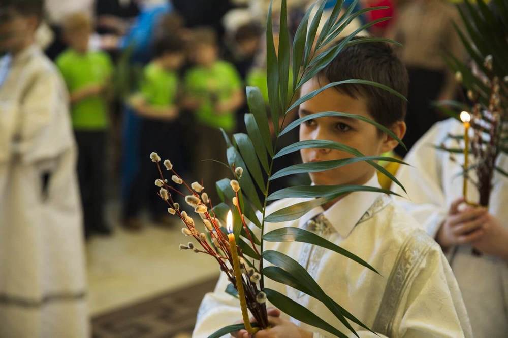 Мальчик в церкви с вербой, свечой и пальмовой ветвью в руках