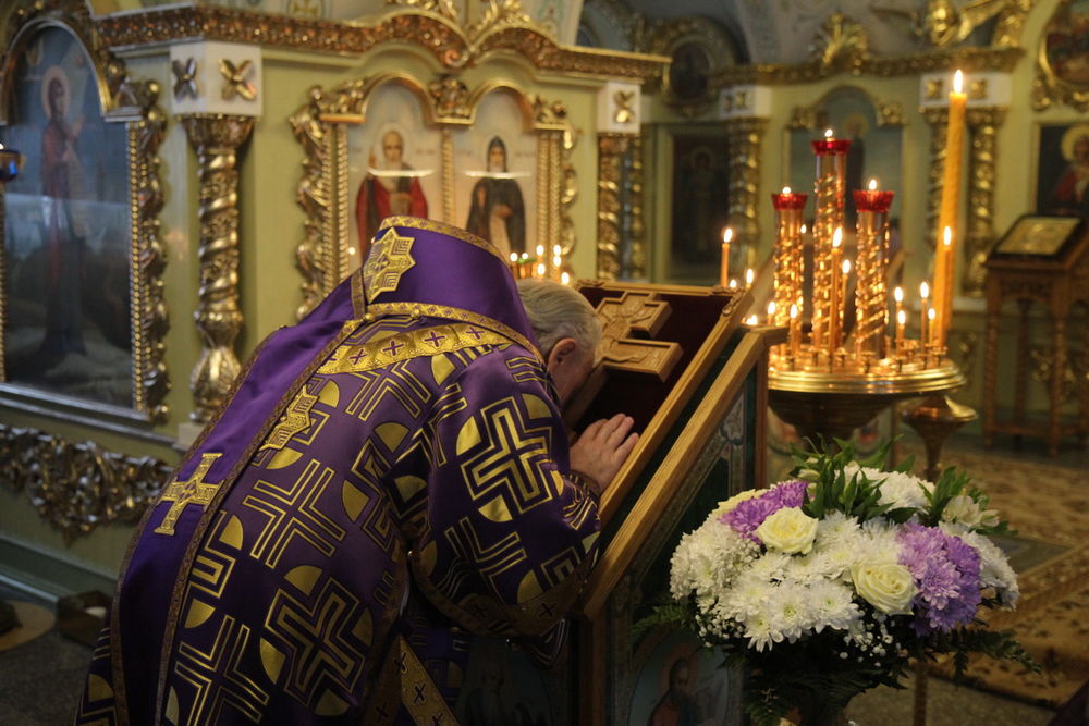 Священник возле креста в церкви