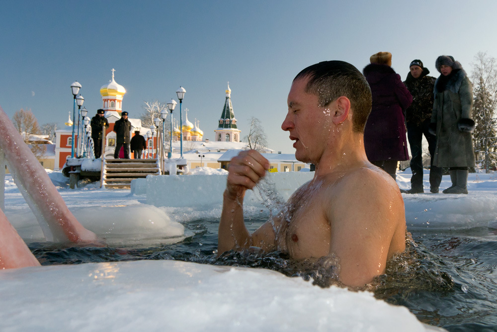 Мужчина в купели на фоне церкви